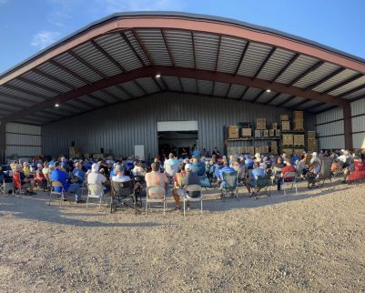 Men's Church group at a outdoor chef cooking class under a metal building cover